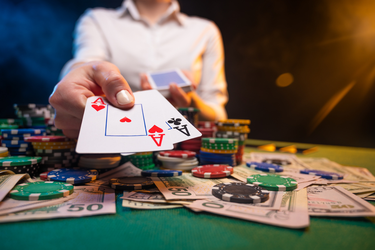 Playing in a casino, online casino. A player opens cards with two aces. Money, poker table, chips. Background for the gaming business, and online casinos.